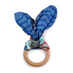 a wooden ring with blue and red fabric wrapped around it's head on a white background