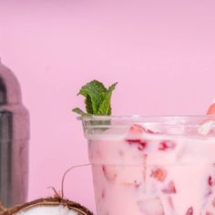 a person holding a strawberries and yogurt in front of a pink background