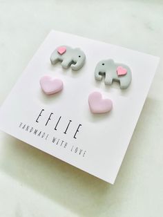 an elephant and heart shaped studs on top of a card