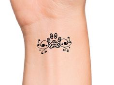 a black and white tattoo design on the wrist