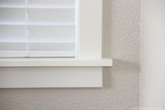 a white cat is sitting in the window sill