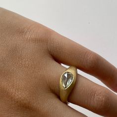 a person's hand with a gold ring on it and a diamond in the middle