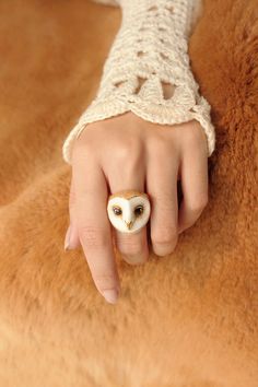 a woman's hand with an owl ring on it