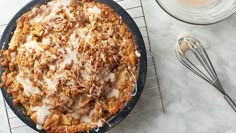 an apple crumbler cake on a cooling rack next to some whisks