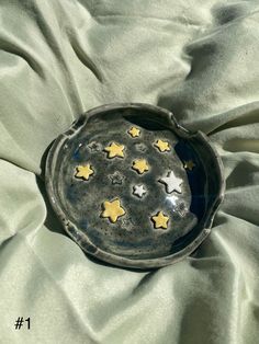 a metal bowl with stars on it sitting on a green cloth covered tablecloth, top view