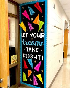 a sign that says let your dreams take flight on the side of a wall in a hallway