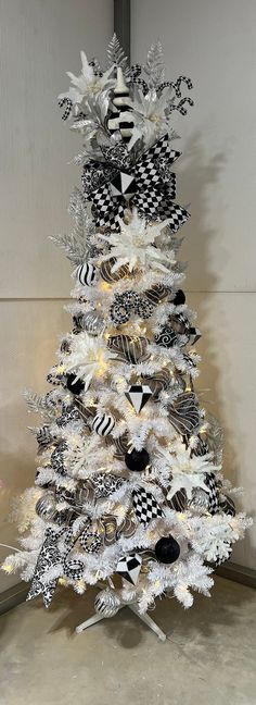 a white christmas tree with black and white decorations