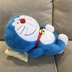 a blue stuffed animal laying on top of a couch