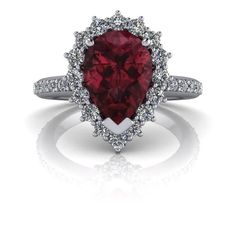 a red heart shaped diamond ring with white diamonds around it and the center stone is surrounded by