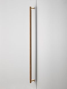 a door handle on the side of a white wall with a wooden stick sticking out of it