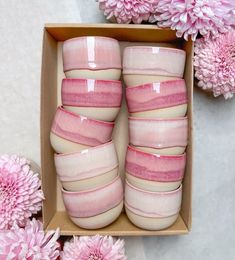 pink and white vases in a box with flowers