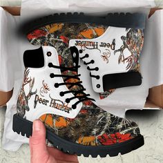 a pair of white boots with black and red designs on them, in a box