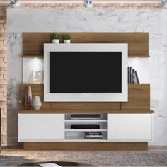 an entertainment center with a flat screen tv mounted on the wall and shelves below it