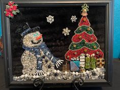 a snowman and a christmas tree made out of beads in a shadow box frame