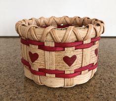 a woven basket with hearts on it sitting on a counter