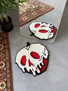 two round rugs with red and white designs are on the floor in front of a mirror