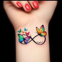 a woman's wrist with two butterflies on it and the word love written in butterfly tattoos