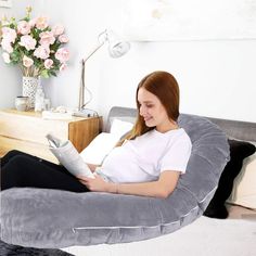 a woman sitting in a chair reading a book