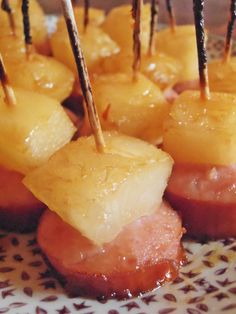 pineapple and ham appetizers with toothpicks on a white and brown plate