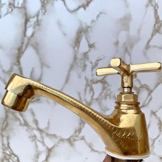 a golden faucet on top of a marble counter