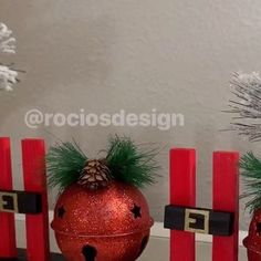 three red christmas ornaments sitting on top of a table next to a white and silver tree