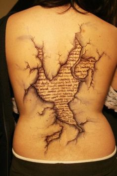 the back of a woman's body is shown with writing on it and cracked paint