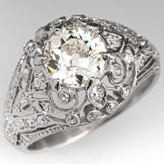 This finely detailed ring features a pierced design with milgrain details and is centered with a round old European cut diamond, weighing 1.20 carats, in a four-prong setting. The top of the ring is bead set with a total of fifty (50) round single cut diamonds. The ring measures 12.6mm at the top, rises 5.7mm above the finger, tapering to 2.2mm wide and 0.8mm thick at the base of the shank. The ring is a tight fitting size 6 and there is an old resizing seam at the back of the band that will be Antique Cocktail Ring, Vintage Wedding Jewelry, Vintage Jewellery Rings, Antique Diamond Rings, Dome Ring, Detailed Ring, Bead Set, Antique Engagement Rings, Domed Ring