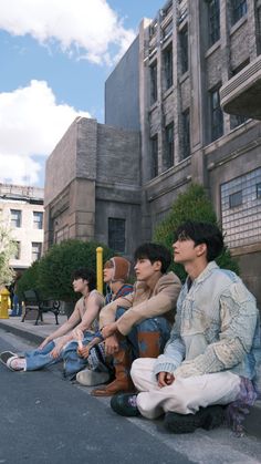 three men sitting on the curb in front of a building with no one around them