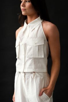 Blossom button up collared halter top in crisp white. BB-SH-24SS-02 PIPE AND ROW White Collared Top For Work, Fitted White Blouse With Pockets, White Tops With Pockets And Collared Neckline, White Cropped Tops For Workwear, Fitted Tops With Pockets For Daywear, Fitted White Tops With Pockets, White Fitted Tops With Pockets, Collared Halter Top, Halter Blouse