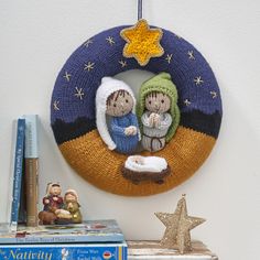 the nativity scene is hanging on the wall next to books and a christmas ornament