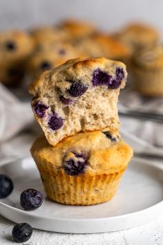 two blueberry muffins stacked on top of each other in front of another muffin