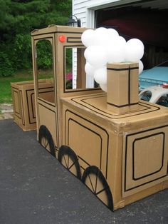 a cardboard train with balloons attached to it