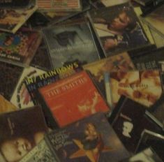 a pile of cds sitting on top of a wooden table