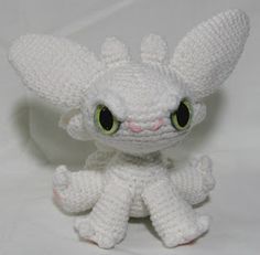 a white crocheted stuffed animal with big eyes