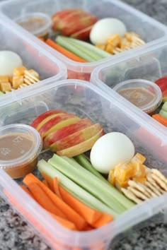 four plastic containers filled with different types of food