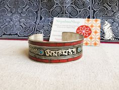 A very beautiful cuff bracelet in Nepalese Coral and hand-worked Tibetan silver. The metalwork is very fine in its chiseling. The inscriptions on the bracelet is the most popular mantra in Nepal and Tibet "OM MANI PADME HUM" means "The jewels of the lotus". It is said that it was given to us by all the Buddhas in their immense compassion for all that lives. OM is composed of three letters actually "A U M" symbolizing body, speech and mind (pure when it comes to a Buddha, a person who has reached enlightenment after practicing intensive and rigorous purification). MANI, "the Jewel", symbolizes the intention to become an enlightened, compassionate and loving being. PADME, means "lotus" and symbolizes wisdom. HUM, indicates indivisibility This mantra allows us to awaken our memory as a divine Om Mani Padme Hum, Nature Jewelry, Tibet, Mantra, Nepal, Cuff Bracelet, Metal Working, Cuff Bracelets, Lotus