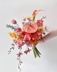 a bouquet of flowers is being held by someone's hand on a white background