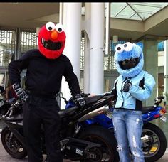 two people in costumes standing next to a motorcycle and sesame the cookie monster on it