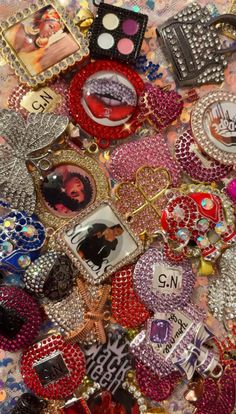 many different types of brooches and other items on a table with some people's pictures