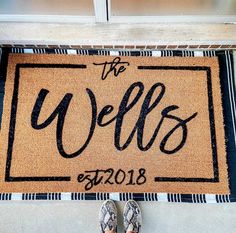 someone standing in front of a welcome mat with the words'the wells'on it