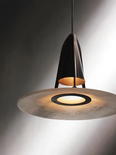 a light hanging from a ceiling fixture in a room with grey walls and flooring