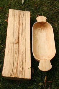 two wooden spoons sitting next to each other on the grass