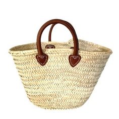 a woven basket with brown handles and leather accents on the handle is shown in front of a white background