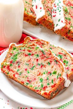 two slices of christmas sprinkle cake on a plate next to a glass of milk