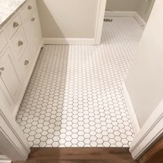 a bathroom with white tile and wood flooring next to a toilet in the corner