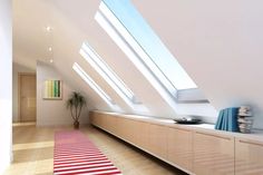 an empty room with skylights and a rug on the floor in front of it