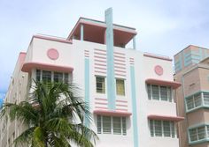 a pink and blue building with palm trees in front