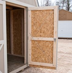 an open barn door with the inside walls boarded up