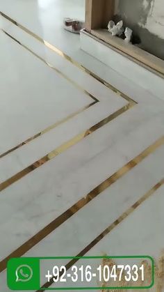 a white marble floor with gold lines in the middle and a green box on the ground