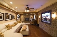 a living room filled with lots of furniture and a flat screen tv mounted to the wall